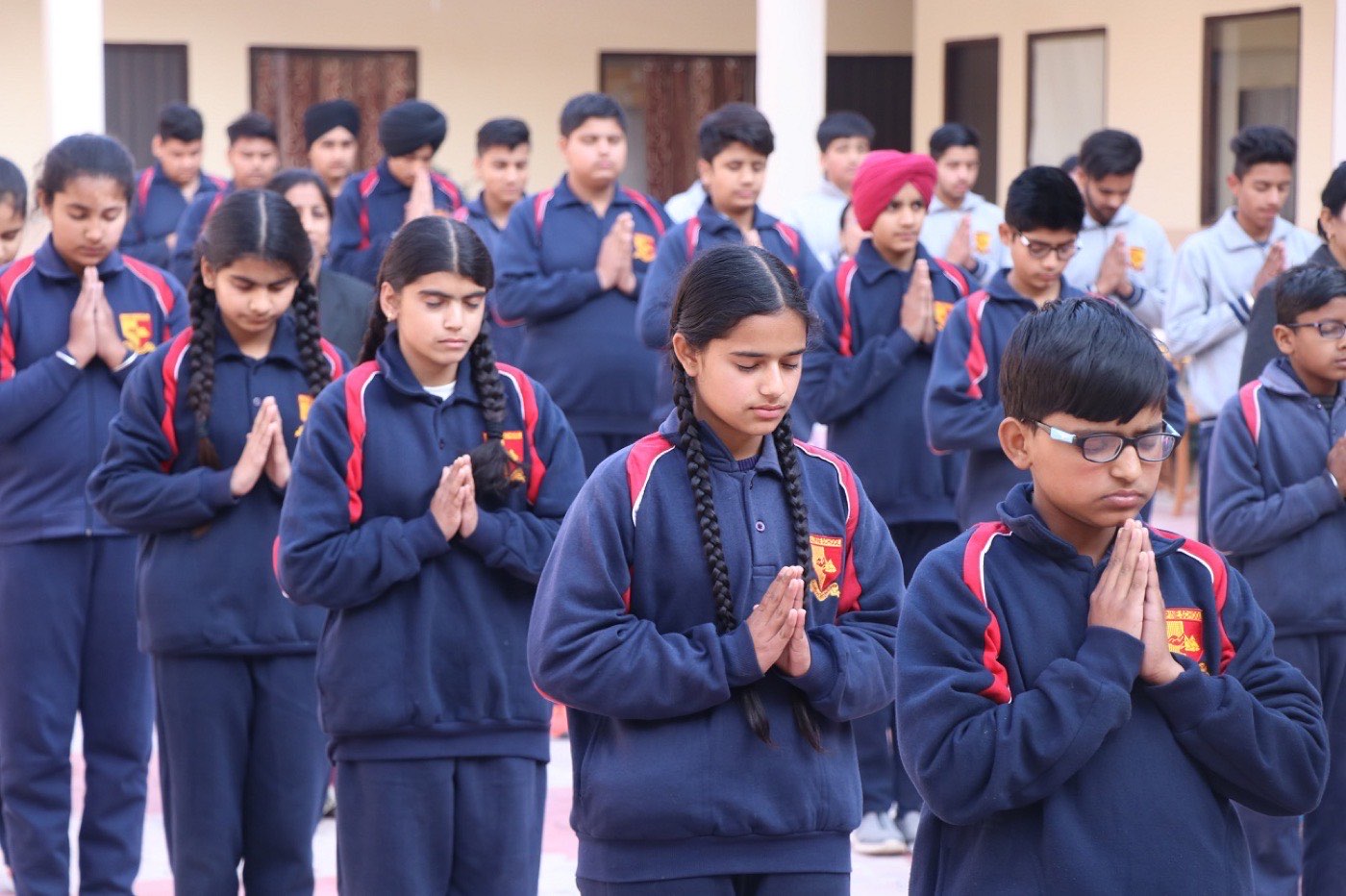 Students standing with folded hands during morning assembly